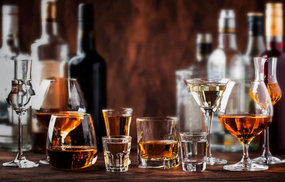 Különböző alkoholok: vodka, konyak, tequila, brandy, whisky, grappa, likőr, vermut, rum fa asztalon