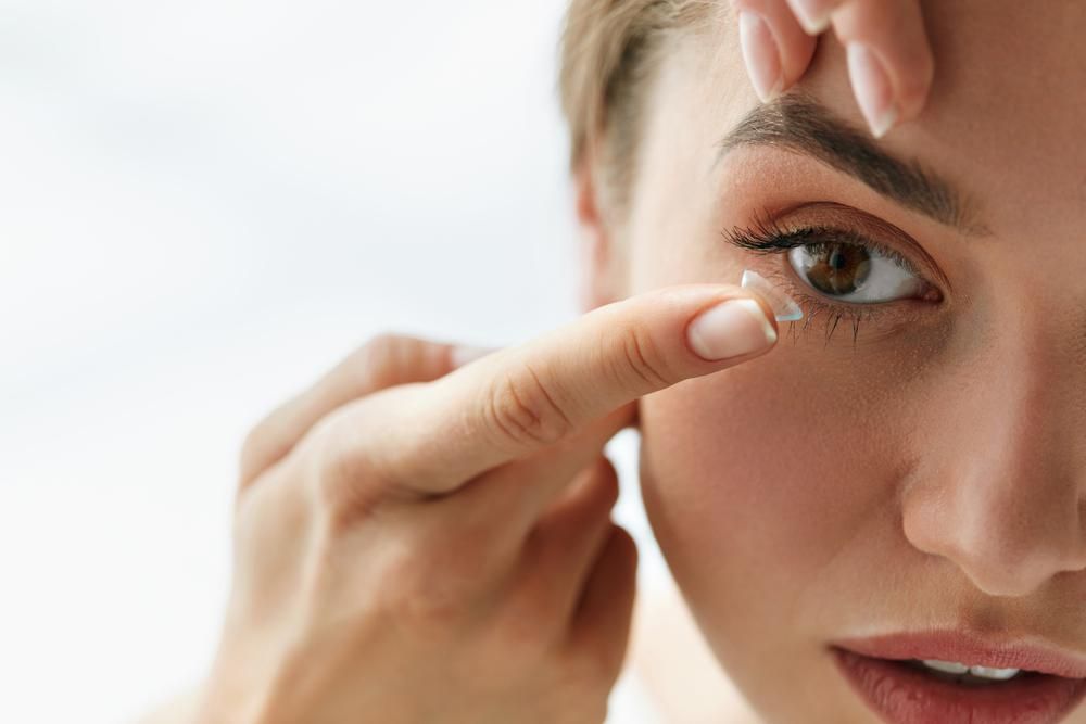 Fiatal nő kontaktlencsét helyez a szemébe