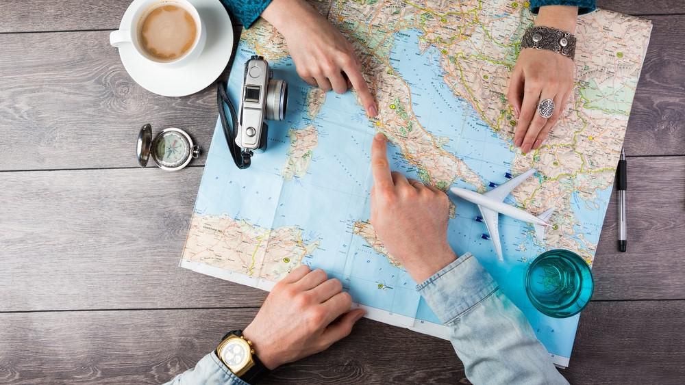 Két ember utazást szervez egy térképpel