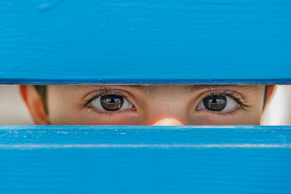 Kisfiú szemei kék fadeszkák között