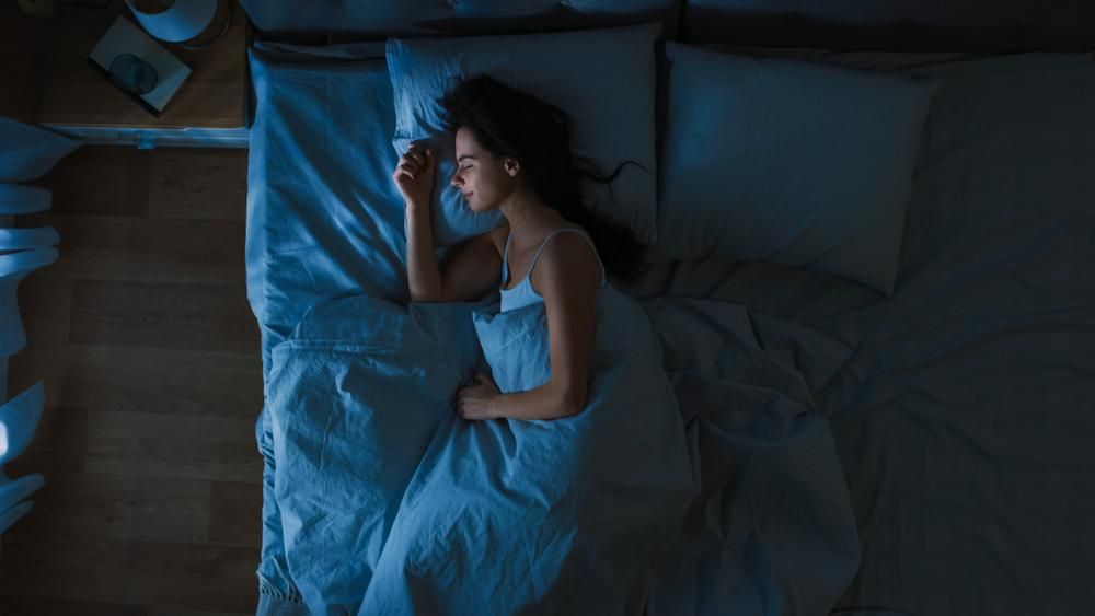 Fiatal nő alszik a hálószobájában éjjel