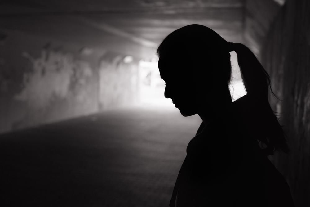 Depressziós fiatal nő áll egy sötét alagútban