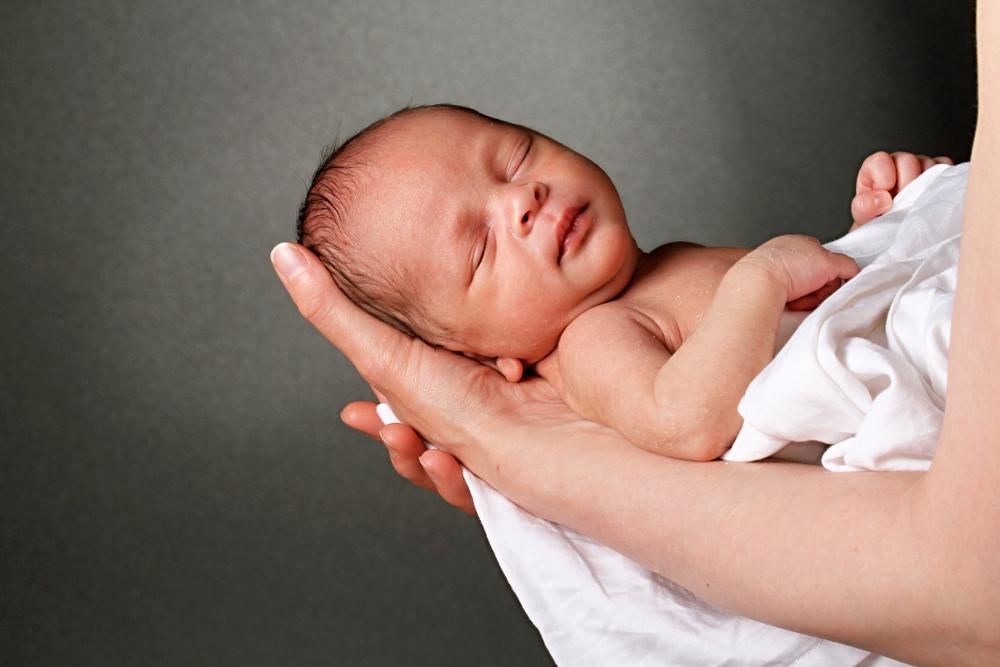 Újszülött babát tartó karok