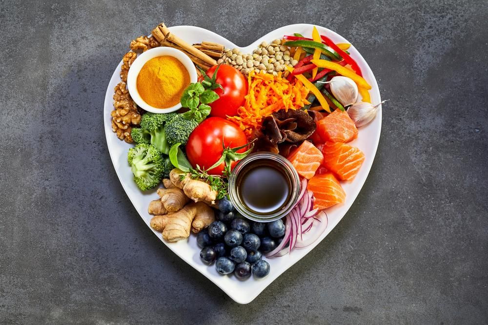 A szív- és érrendszerre egészséges ételek, szív alakú tányéron, szürke háttéren