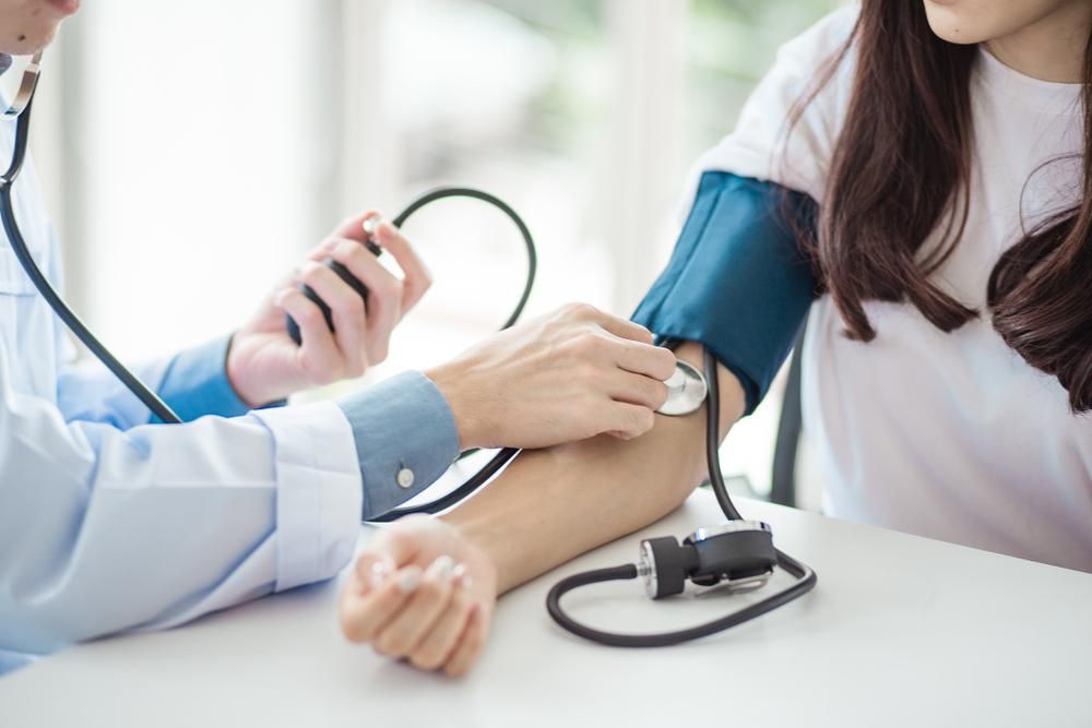 Páciens vérnyomását mérő orvos