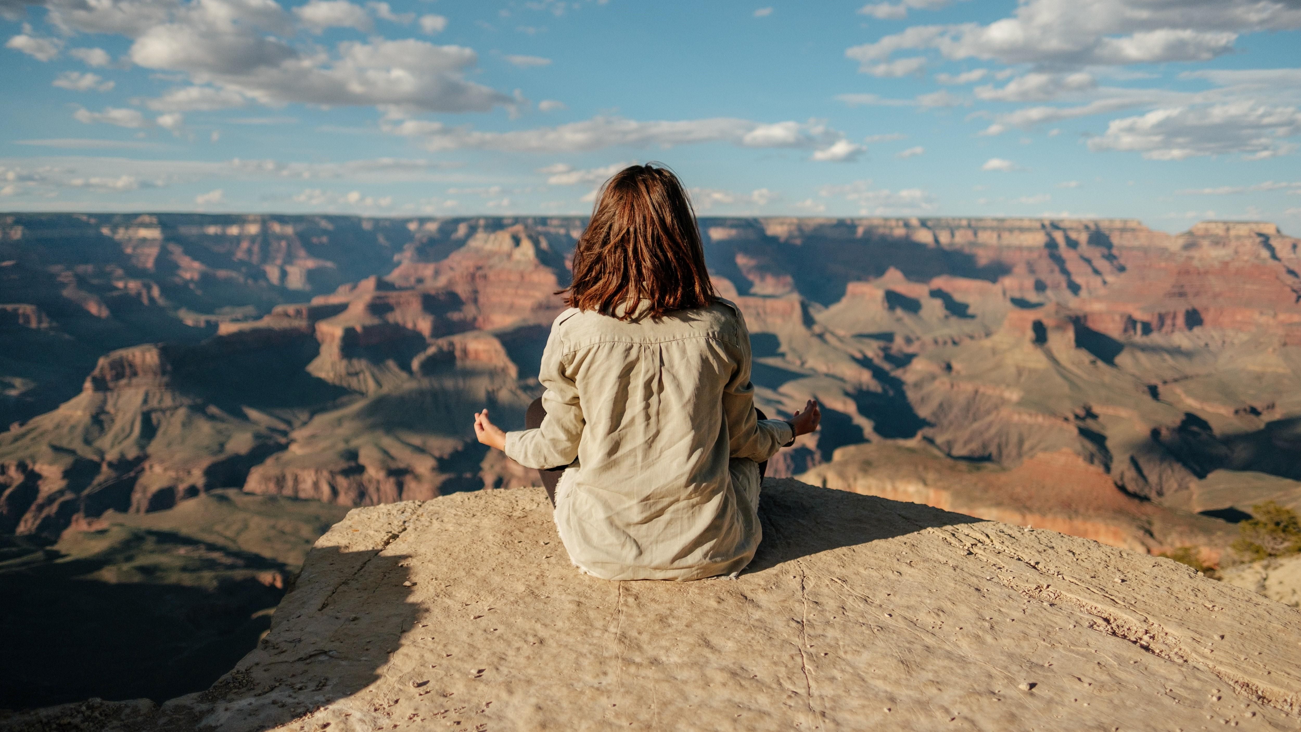 Egy lány meditál a hegy tetején