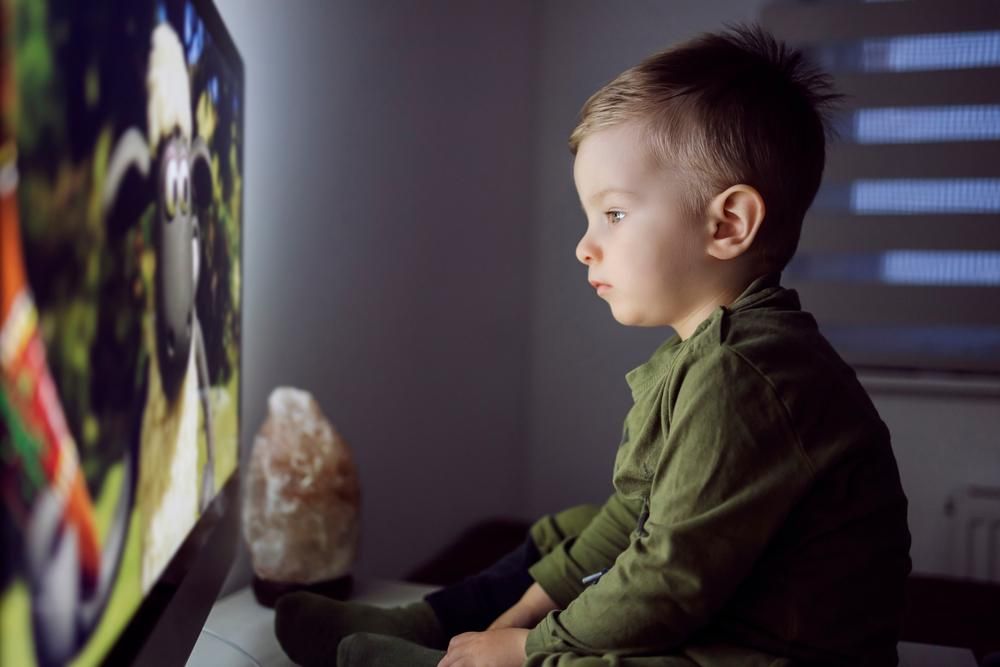 Tévét közelről néző kisfiú
