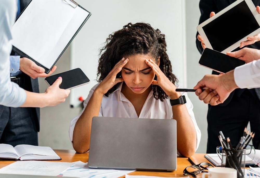 Túlhajszolt nő stresszel a sok feladat miatt a munkahelyén 