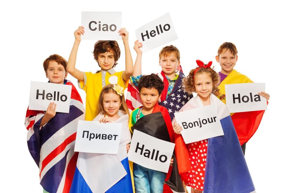 Gyerekek különböző nyelvű üdvözlő táblákat tartanak a kezükben