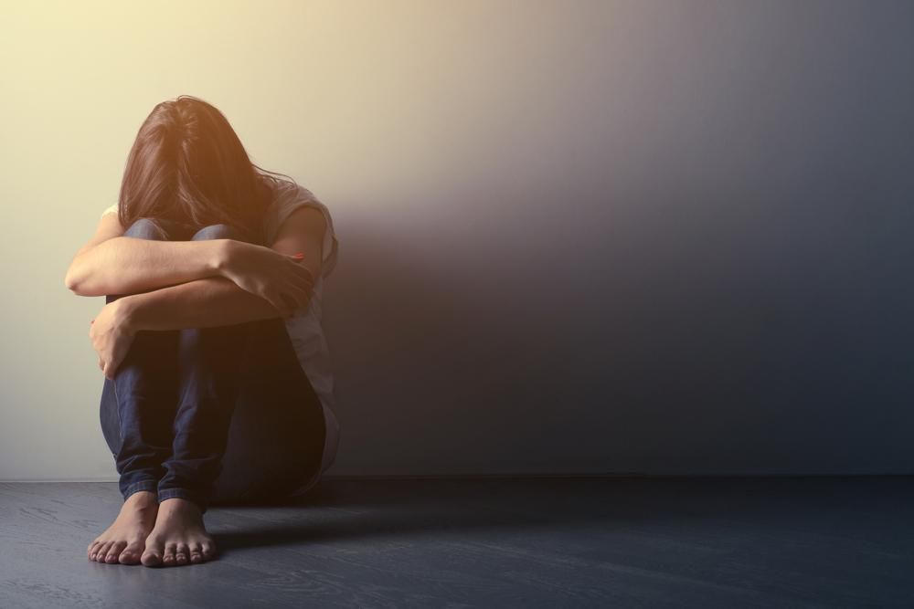 Depressziós kamaszlány ül egyedül a padlón