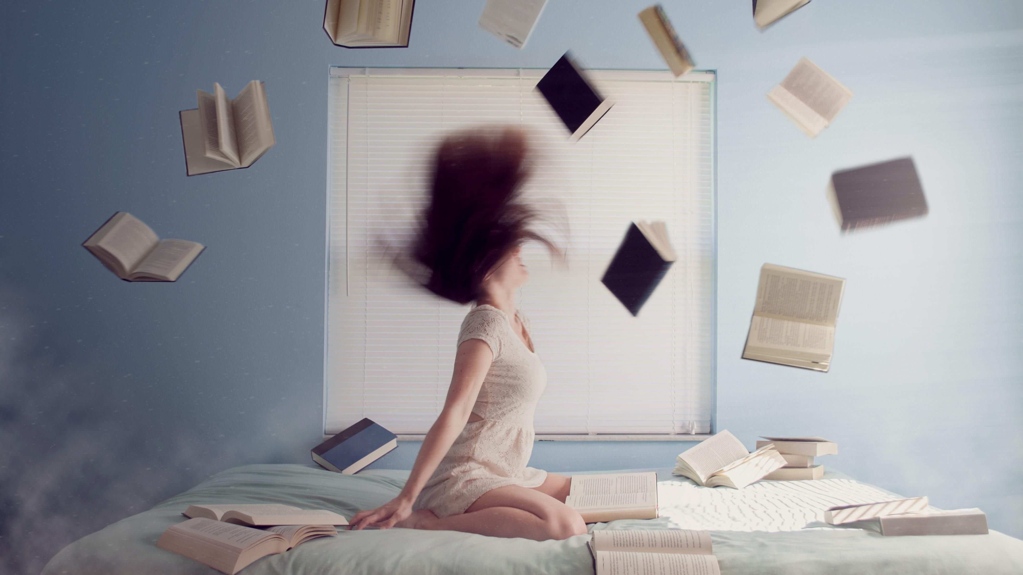 Egy lány a könyvei között a haját dobálja