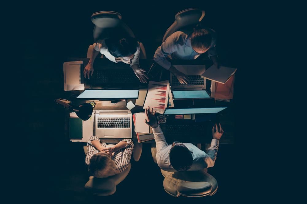 Számítógép előtt ülő, keményen dolgozó emberek felülnézetből