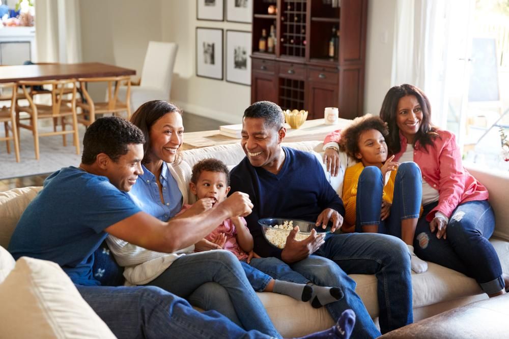 Három generációs afroamerikai család ül a kanapén a nappaliban
