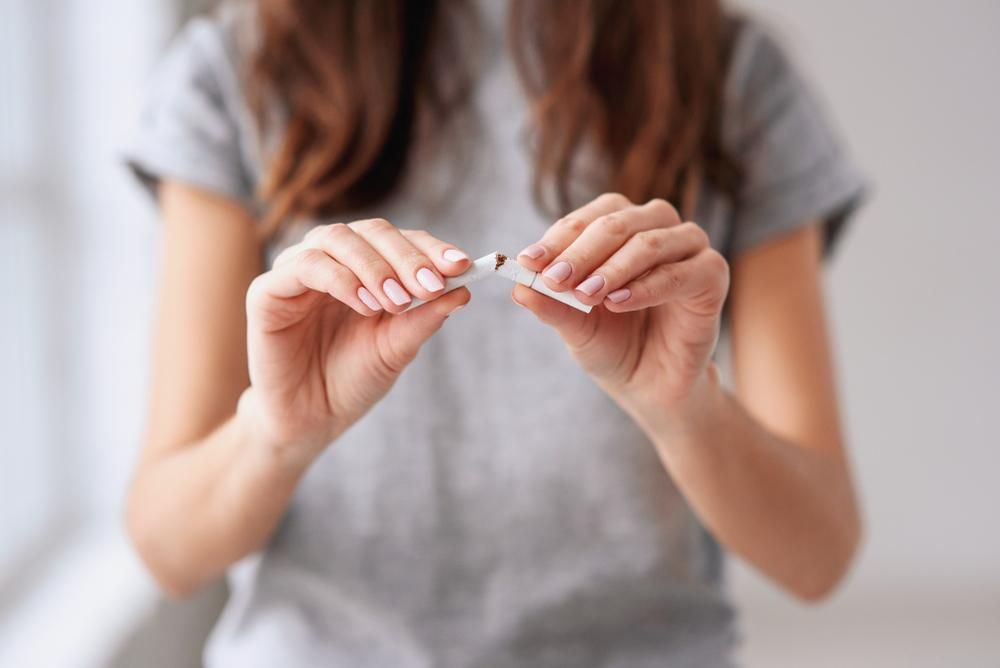 Cigarettát eltörő női kezek