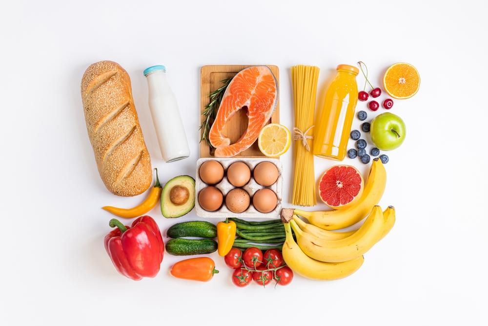 Egészséges ételek: zöldségek, gyümölcsök, halak, tészta fehér háttéren