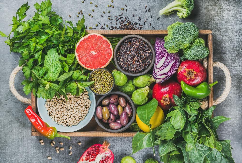 Zöldségek, gyümölcsök, magvak, gabonafélék, bab, fűszerek és gyógynövények fadobozban 