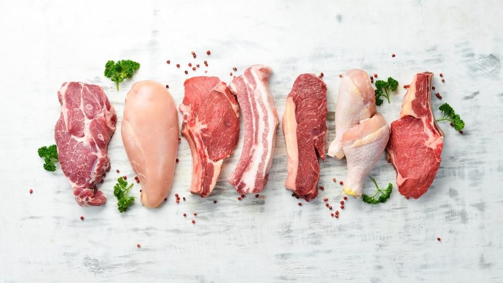 Nyers hús steakek: lazac, marhahús és csirke fehér faháttéren