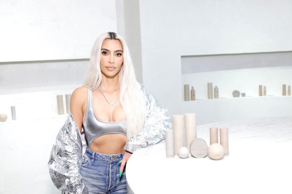 Kim Kardashian világos ruhákban áll egy üzletben