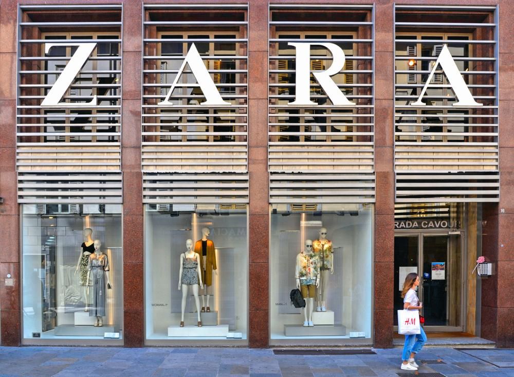 Olaszországi Zara üzlet előtt sétáló fiatal lány H&M márkájú táskával