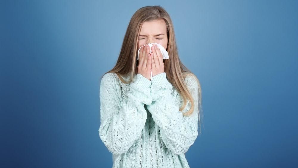 Egy megfázott lány az orrát fújja