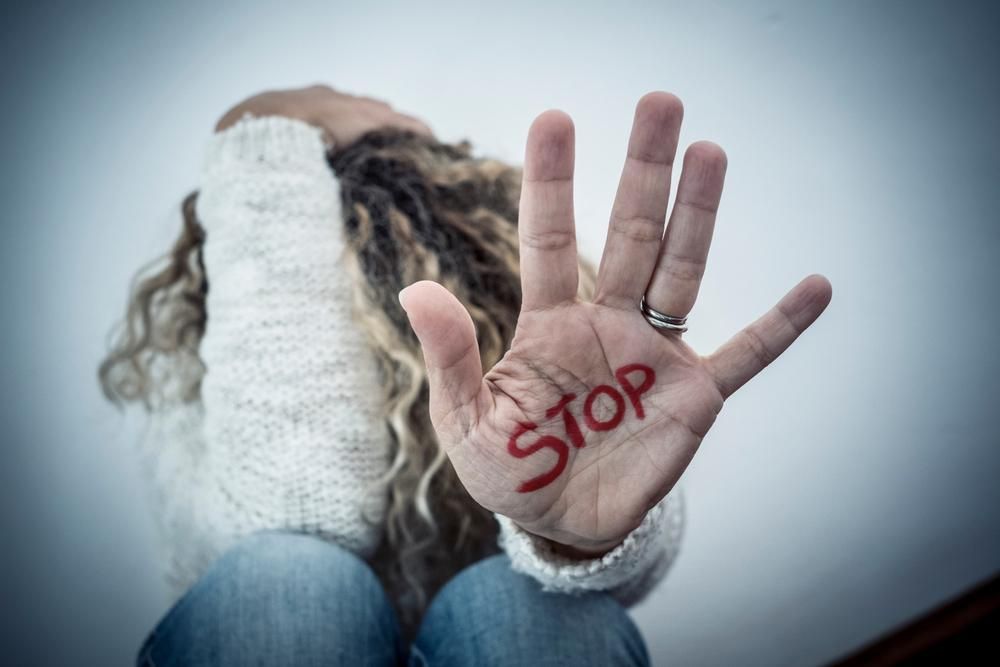Nő STOP felirattal a kezén küzd az erőszak ellen