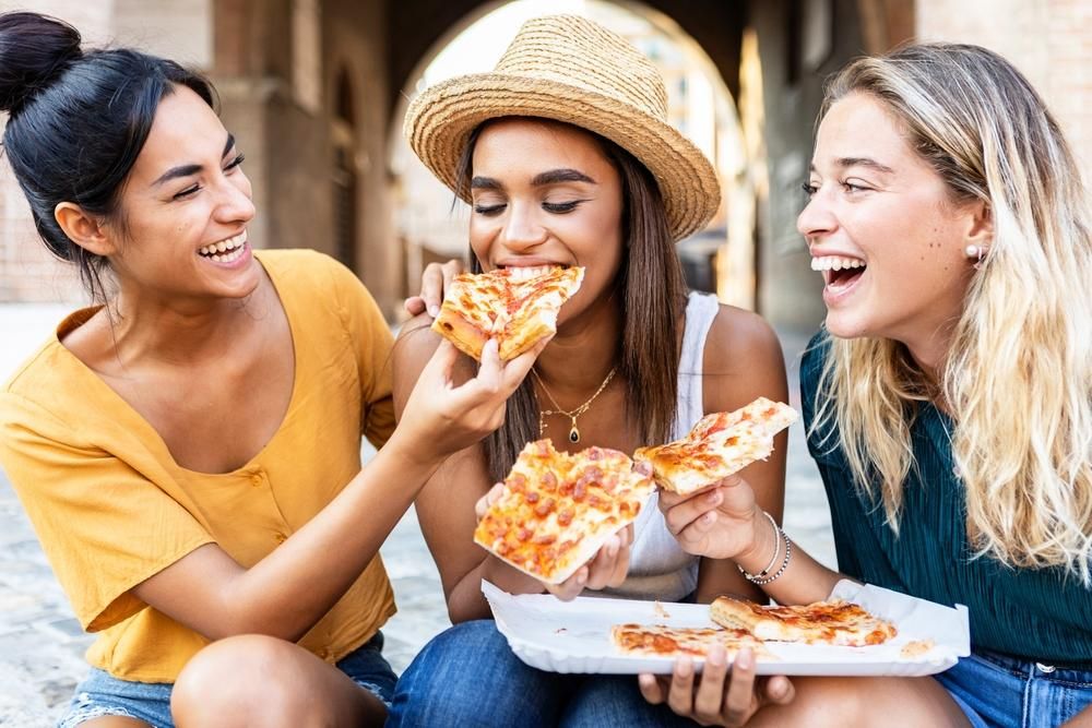 Pizzát evő, vidám barátnők Rómában