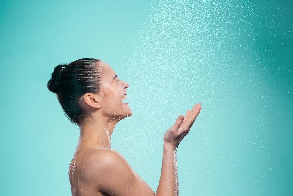 Zuhanyzó nő, türkiz háttér előtt