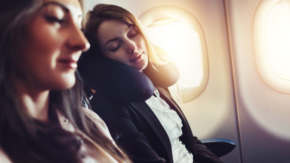 Egy lány alszik a repülőn