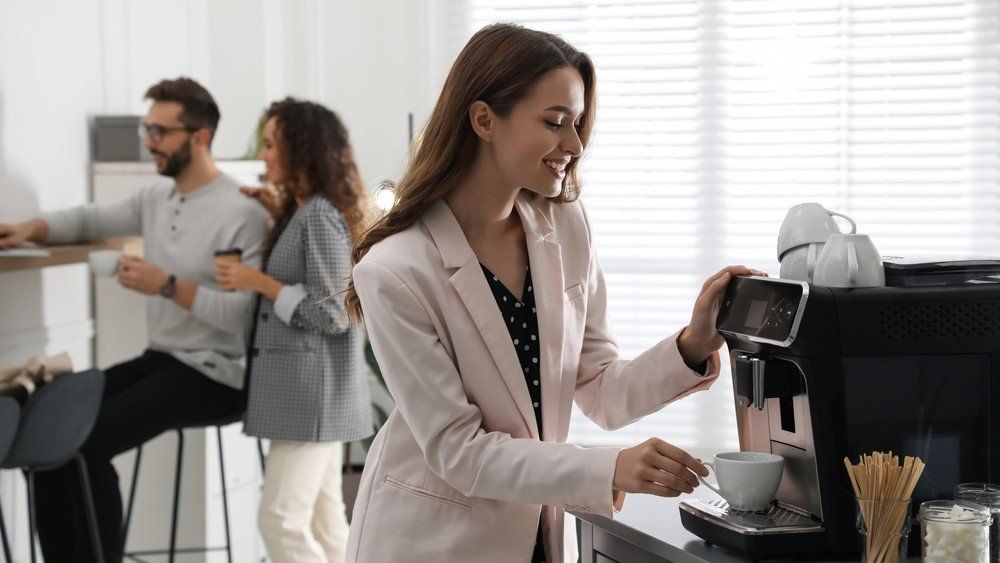 Egy nő kávét készít az irodai konyhában