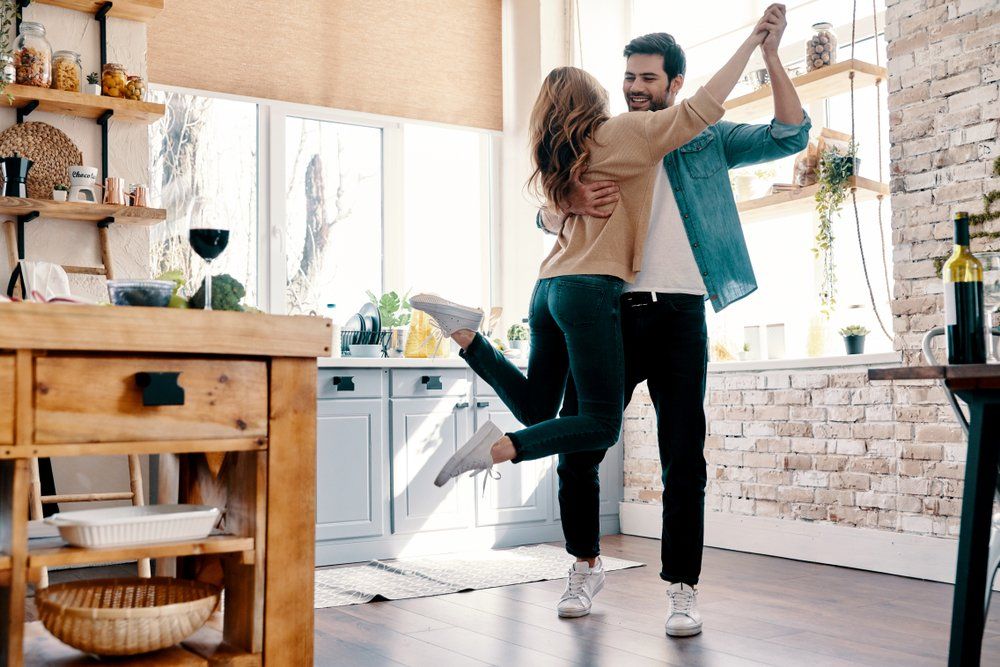 Boldog, vidám házaspár a konyhában táncol