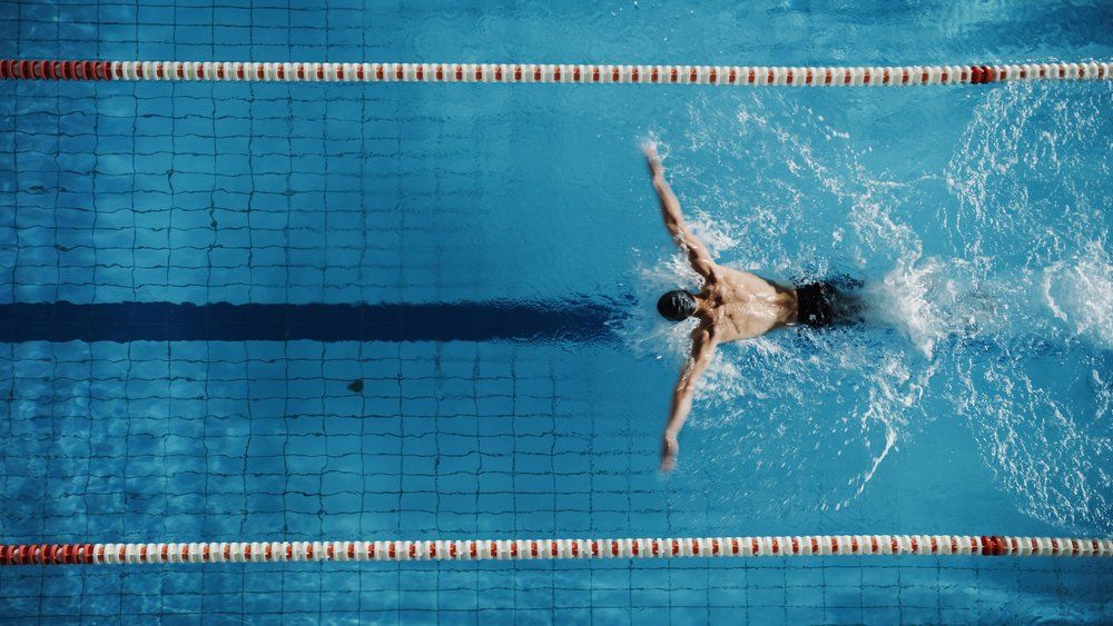 Uszodában úszó férfi