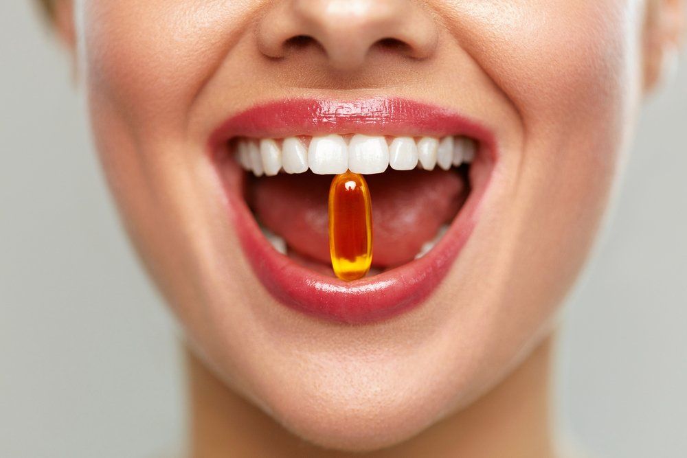 Vitamint a fogai közt tartó női száj