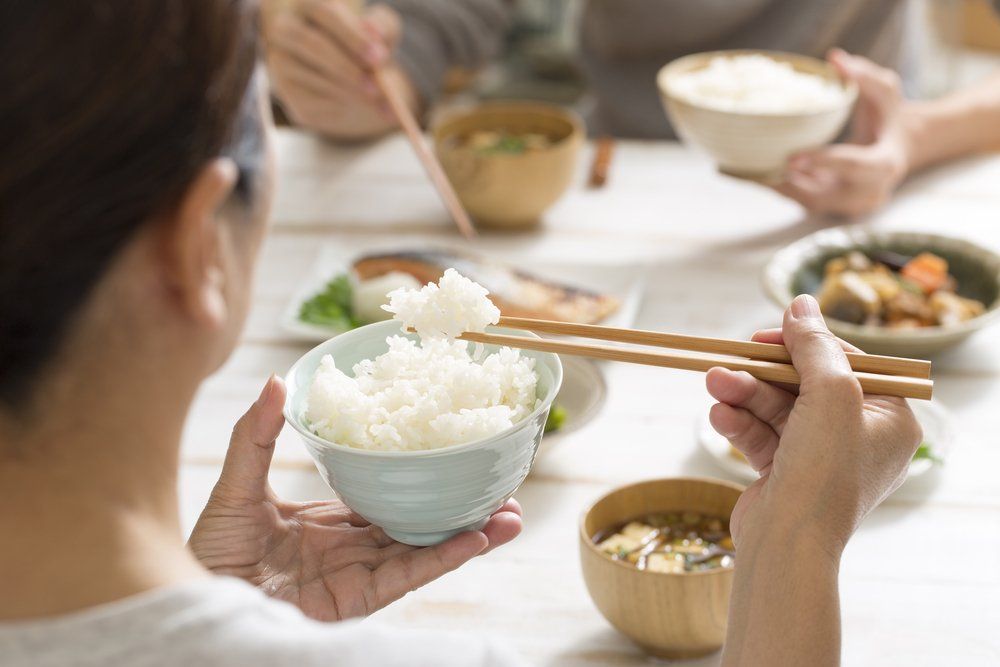 Rizst eszik pálcika evőeszközzel egy japán nő