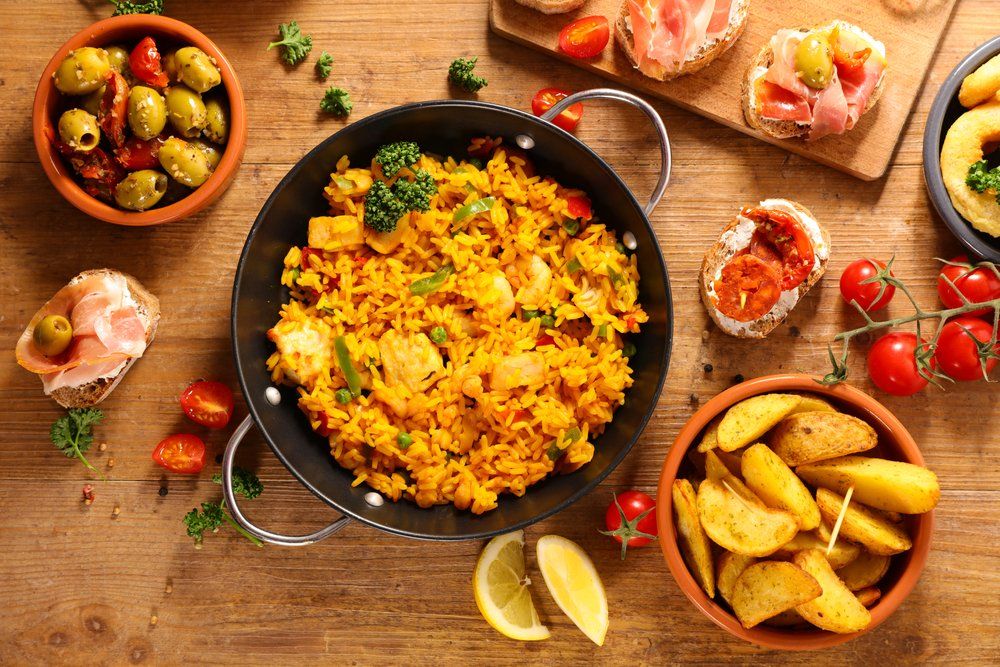 Spanyol ételek egymás mellett egy asztalon: paella, tapas
