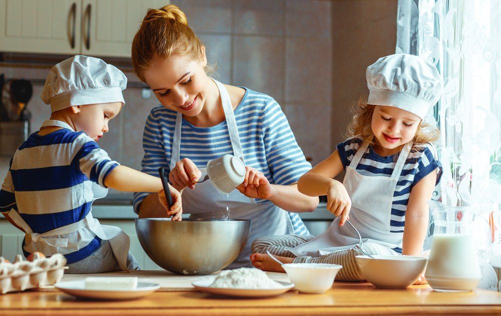 Gyerekeivel süteményt készítő anya
