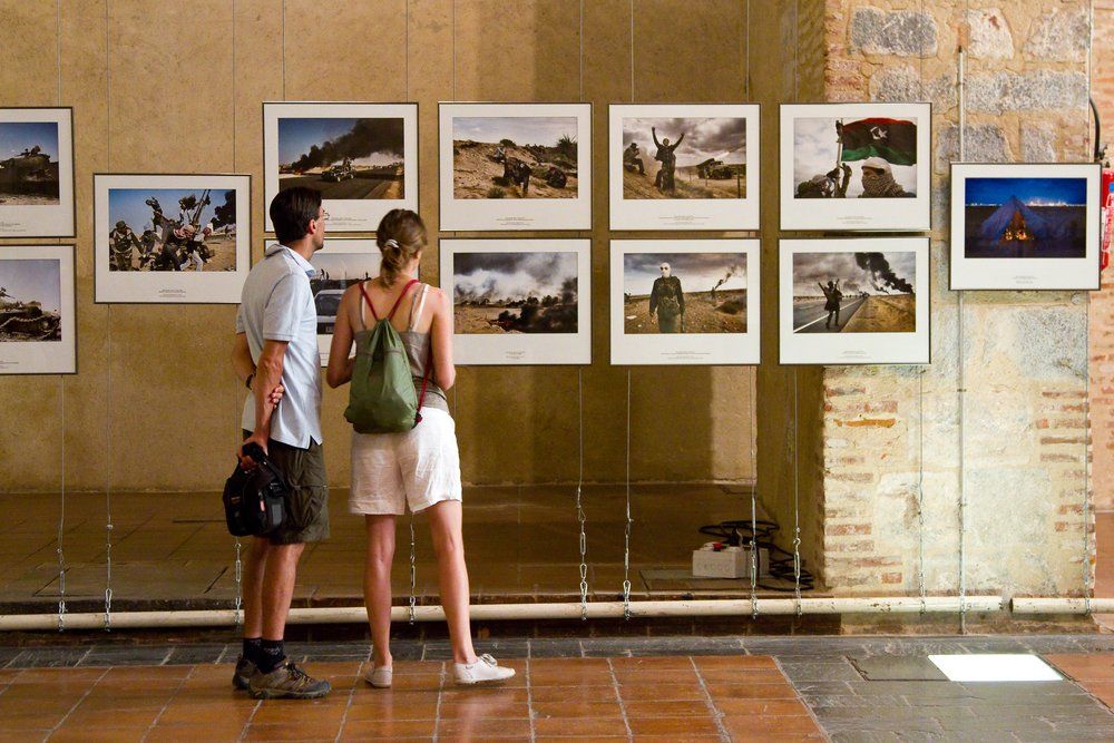World Press Photo-kiállításon áll egy fiatal pár és a képeket nézik