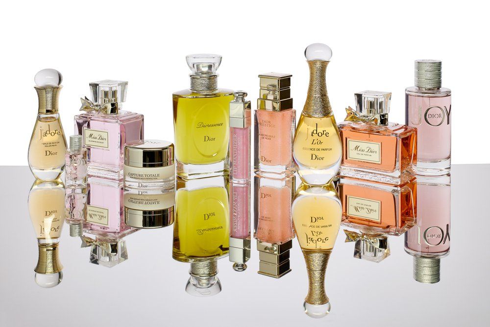 A Dior parfümök és kozmetikai termékek kollekciója fehér háttéren, tükörképekkel