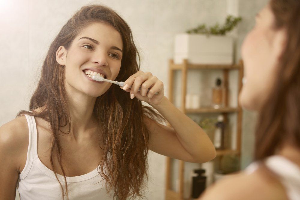 Tükör előtt fogat mosó nő