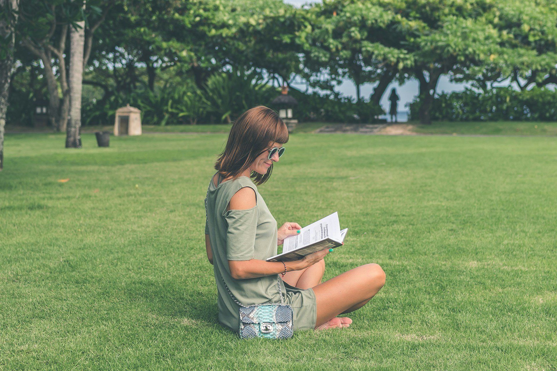 Fűben,ülő és könyvet olvasó nő