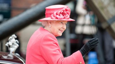 II. Erzsébet brit királynő rózsaszín kosztümben integet