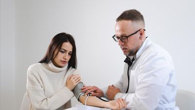 Nő vérnyomását méri a doktor