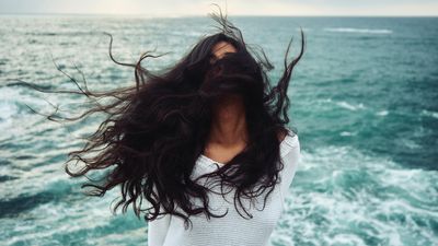 A szél egy lány arcába fújja a haját