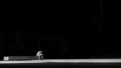 Egy férfi egyedül ül a sötétben