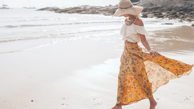 egy nő maxi szoknyában a tengerparton