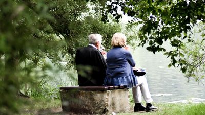 Egy idős pár a patakparton bort iszik