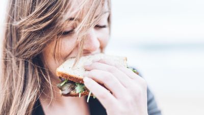 Egy lány a szendvicsébe harap