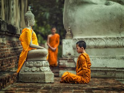 kis tibeti szerzetes tanonc Buddha szobra előtt