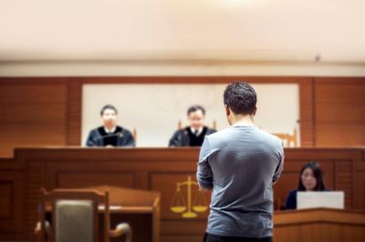 Bíróságon áll egy szürke pólós férfi